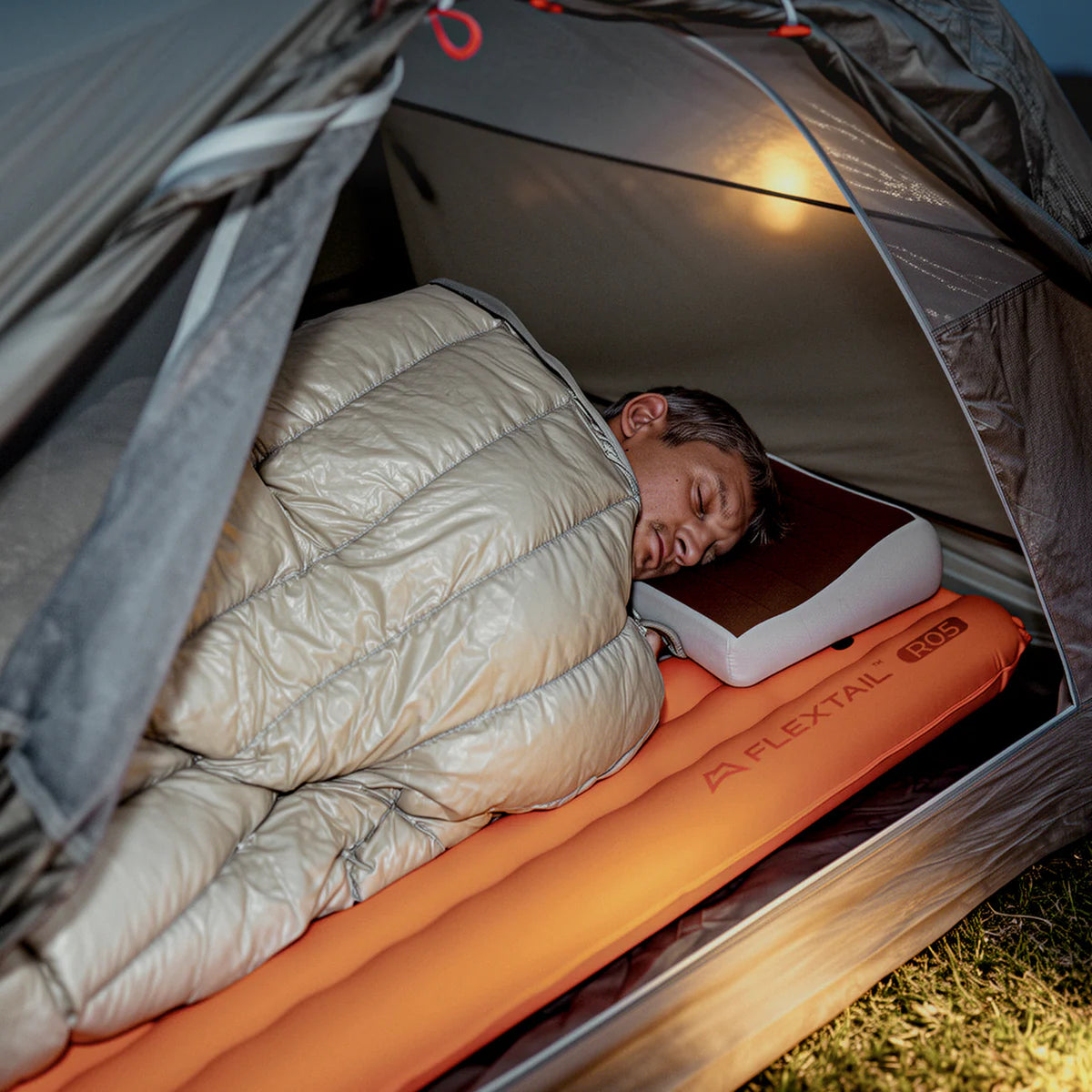 Camper sleeping on Flextail R05 sleeping pad in a tent