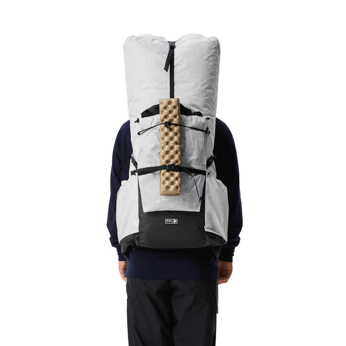 White PPU Tibet 55 backpack worn from the rear with a sleeping pad attached